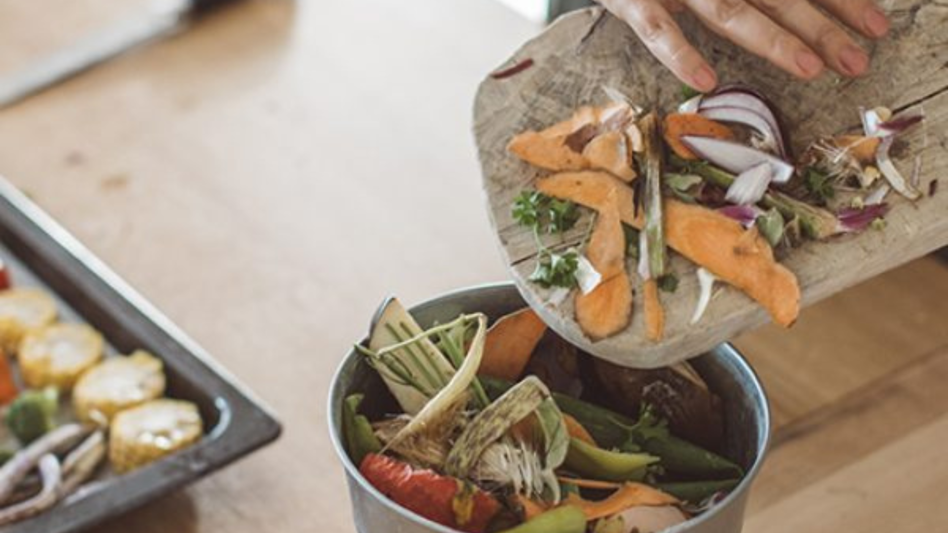 Personne épluchant des légumes frais et mettant les épluchures dans un bol, préparation saine et cuisine anti-gaspillage