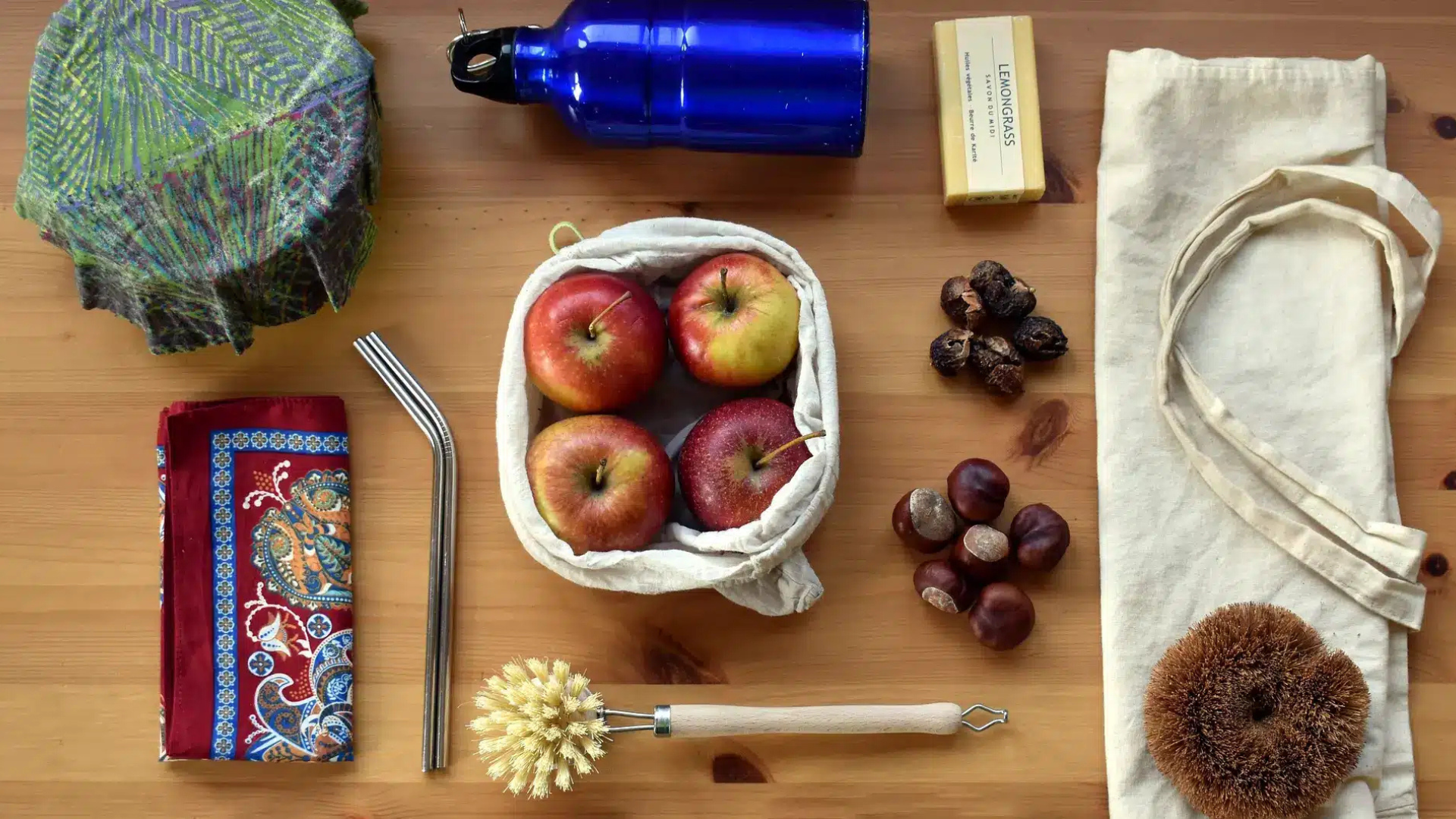 Gourde - marrons - pomme et paille posés sur une table